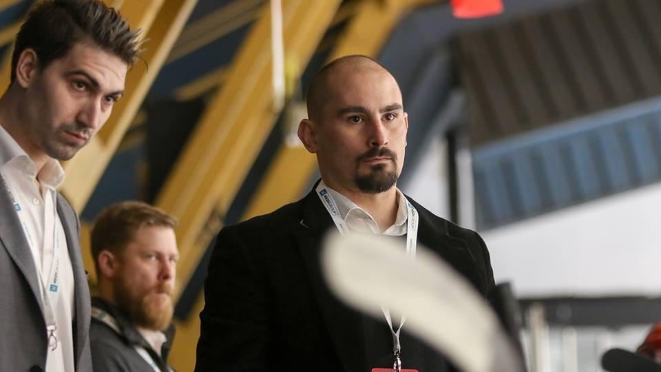 Trois hommes dans un aréna.